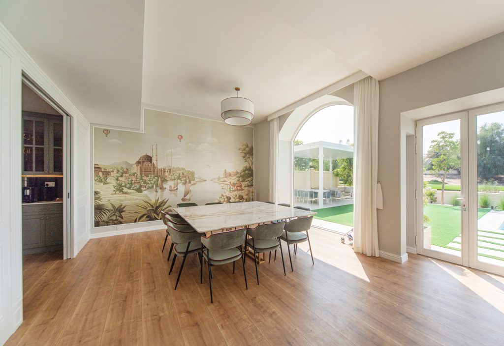 Minimalist Dining Room of The Silk Road Villa, designed by Smart Renovation, featuring earthy tones and mural on accent wall.