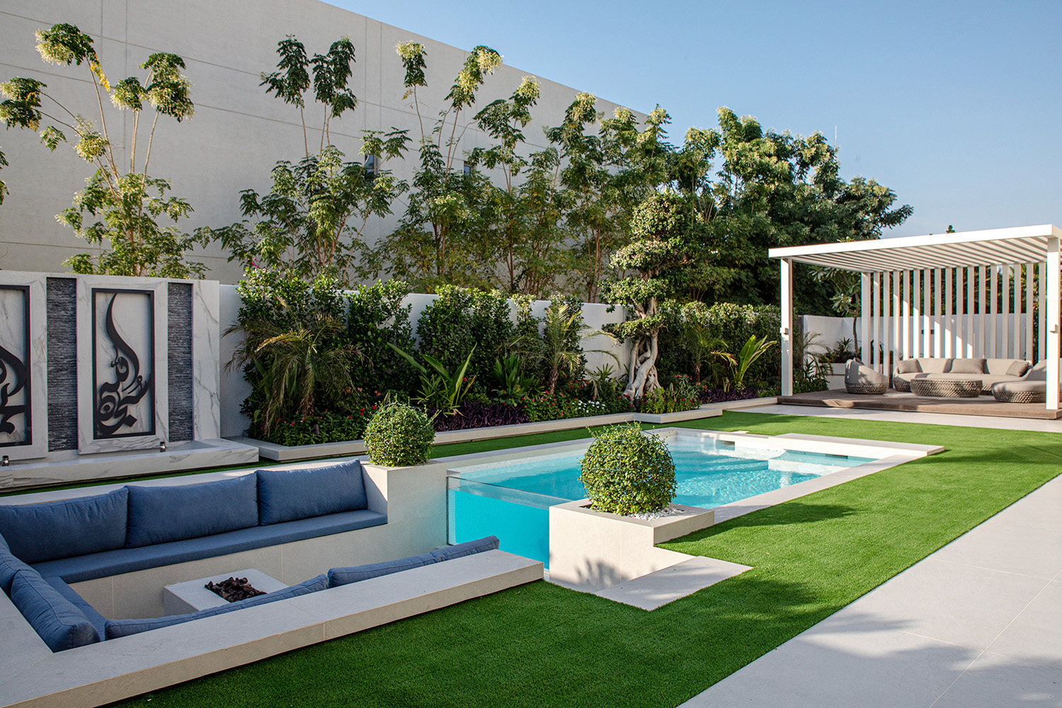 Villa landscaping Dubai with sunken seating area, custom pool, and lush garden design for private outdoor living.