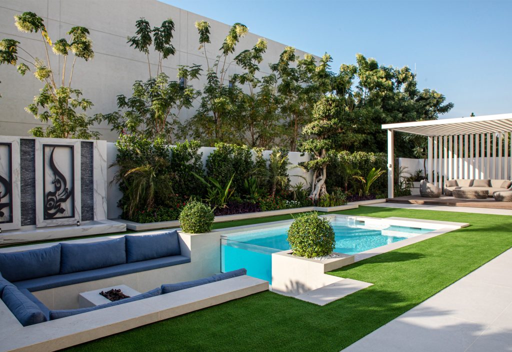Luxurious swimming pool at MBR City Villa by Smart Renovation with deep blue tiles, elegant poolside couch, and serene ambience